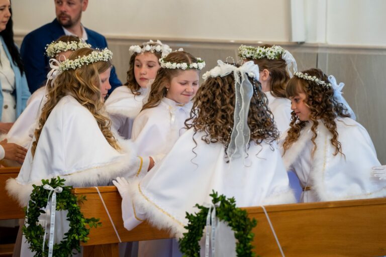 Dziewczynki w wiankach w ławkach kościoła podczas Komunii